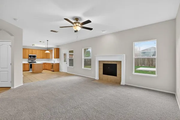 a view of an empty room with a window and fireplace