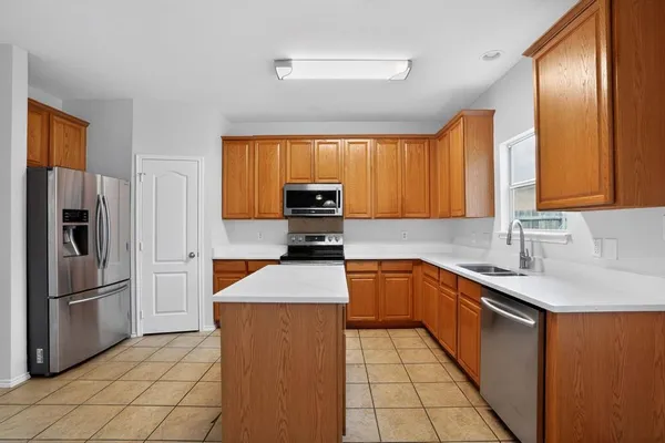 a kitchen with stainless steel appliances granite countertop a sink stove refrigerator and a window