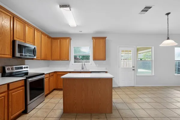 a kitchen with stainless steel appliances granite countertop a sink stove and microwave