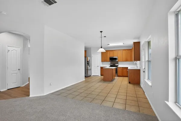 a kitchen with stainless steel appliances kitchen island sink refrigerator and window