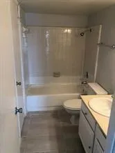a bathroom with a granite countertop sink toilet and shower