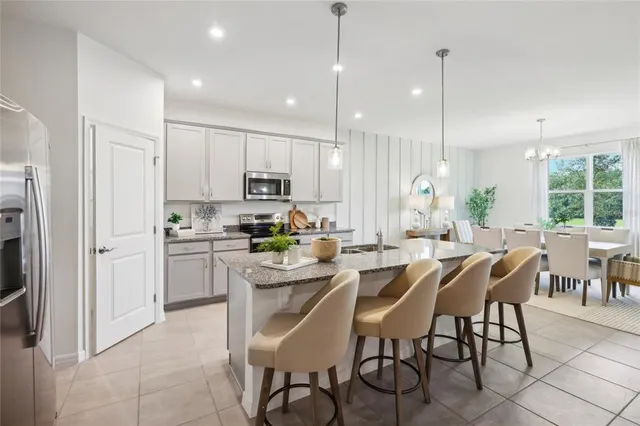 a kitchen with kitchen island white cabinets and stainless steel appliances