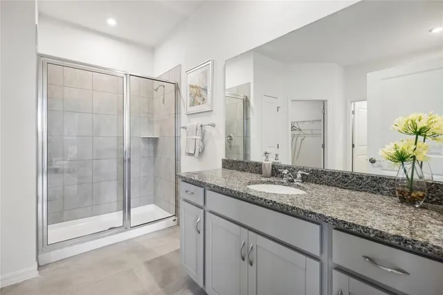 a bathroom with a granite countertop sink mirror and shower