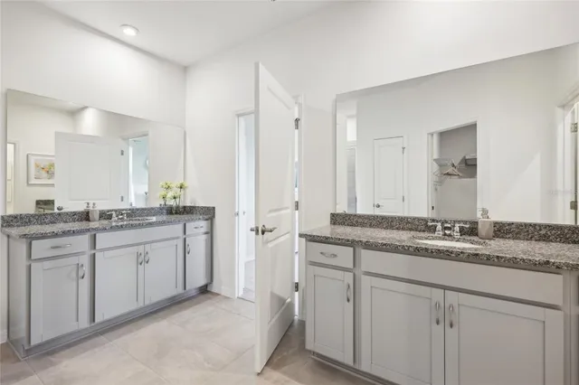 a bathroom with a granite countertop sink double and mirror