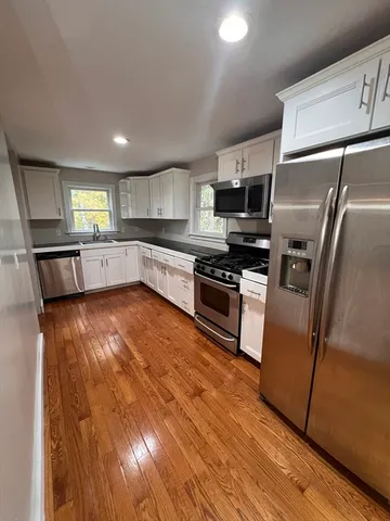 a large kitchen with stainless steel appliances granite countertop a stove a sink and a refrigerator