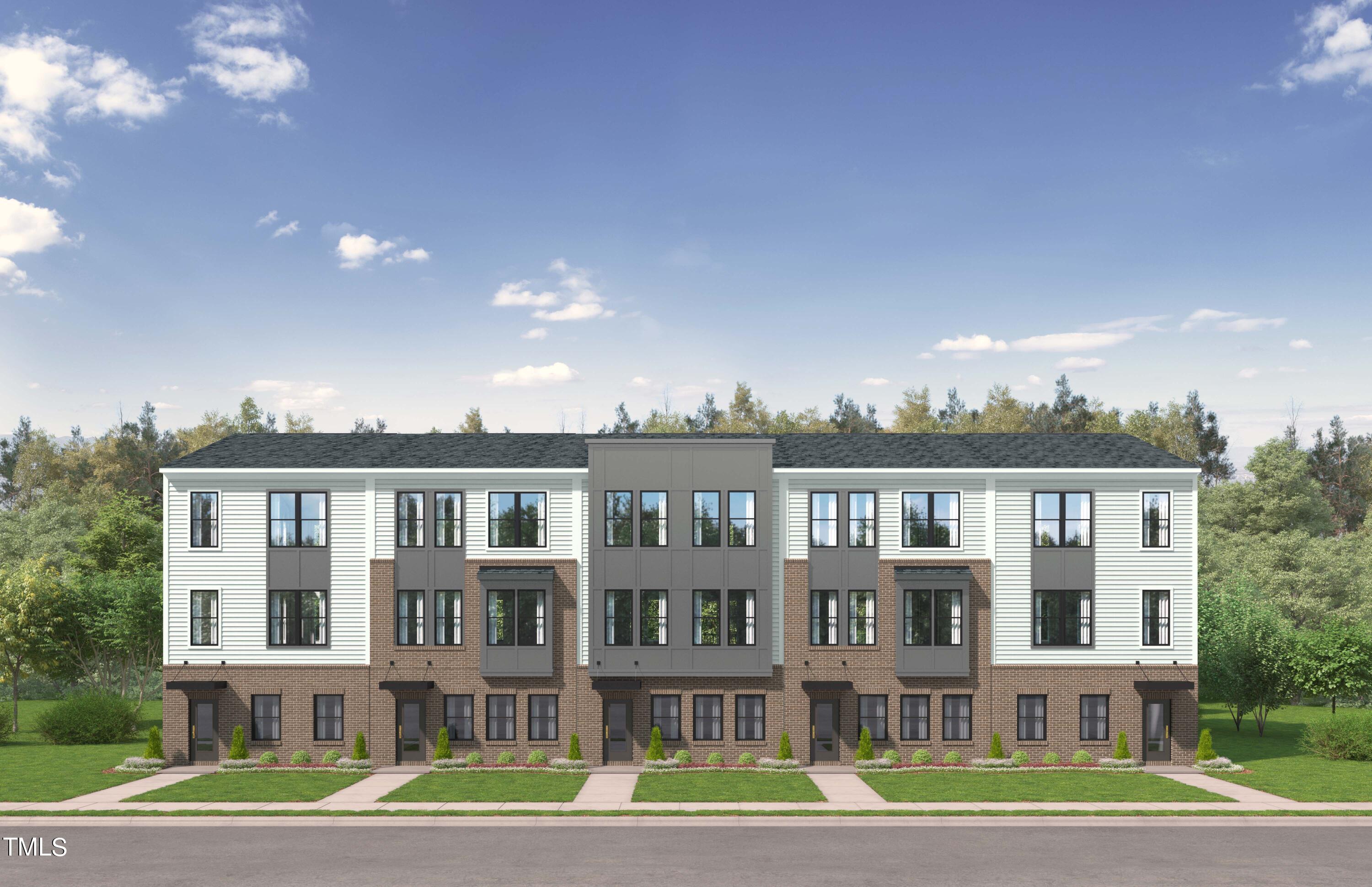 a front view of a residential apartment building with a yard