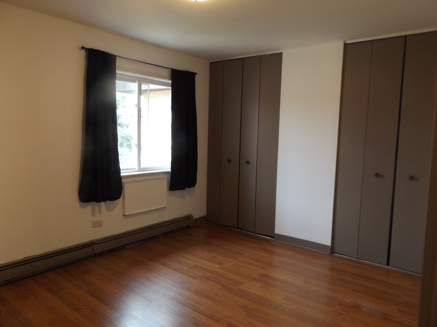710 West Huntington Commons Road, Unit 3A Mount Prospect, IL 60056 - Photo 6 of 10 an empty room with wooden floor and window