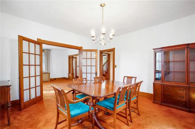 a dining room with furniture a chandelier and wooden floor