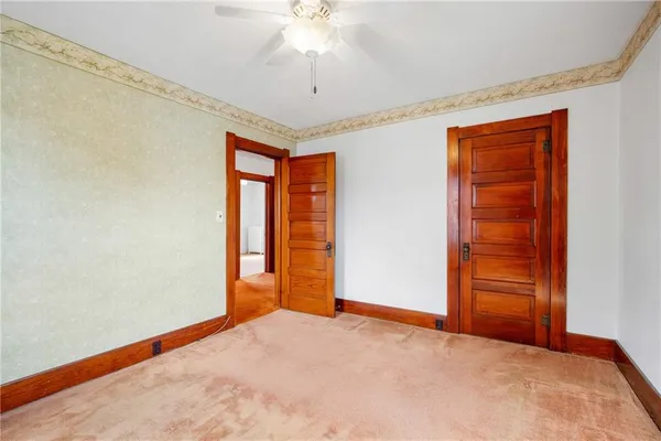 an empty room with closet and chandelier fan