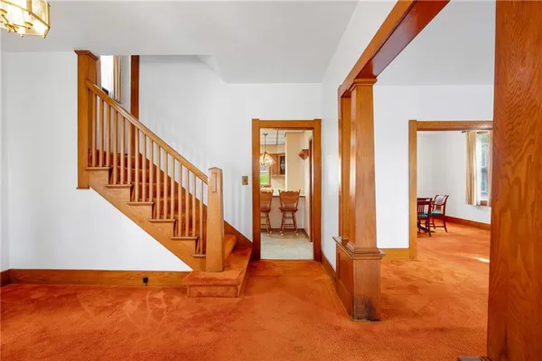 a view of a hallway with wooden floor and stairs