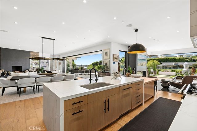 a kitchen with stainless steel appliances a stove a sink a dining table and chairs