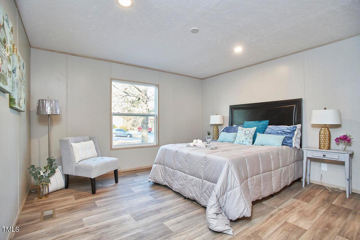 48 Bone Oak Sanford, NC 27332 - Photo 13 of 21 a bedroom with a bed wooden floor and windows