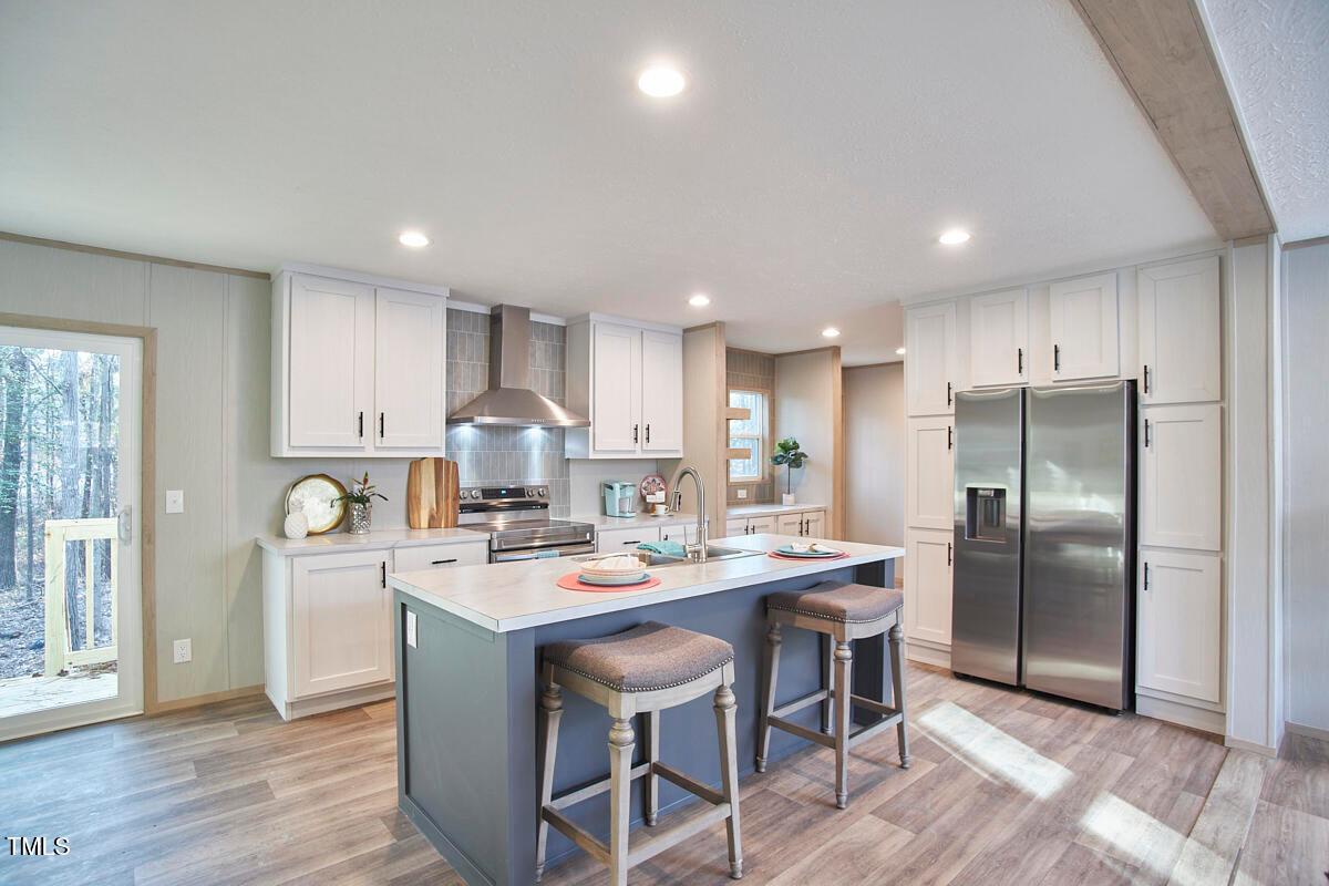 48 Bone Oak Sanford, NC 27332 - Photo 8 of 21 a kitchen with stainless steel appliances granite countertop a dining table chairs refrigerator and cabinets