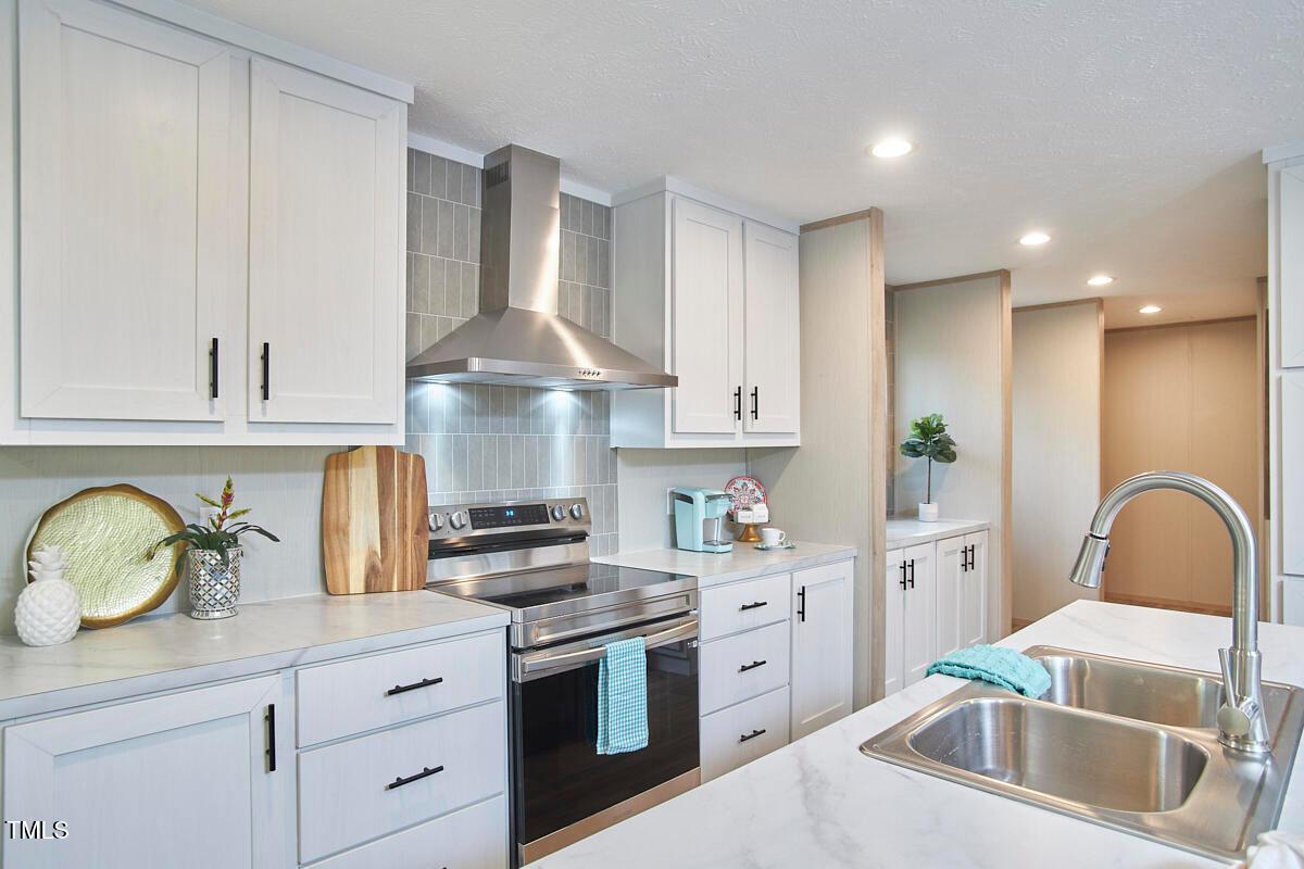 48 Bone Oak Sanford, NC 27332 - Photo 9 of 21 a kitchen with stainless steel appliances granite countertop a sink a stove and cabinets