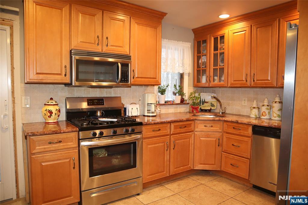 97 Squaw Brook Road North Haledon, NJ 07508 - Photo 8 of 19 a kitchen with stainless steel appliances granite countertop a stove a sink and a microwave