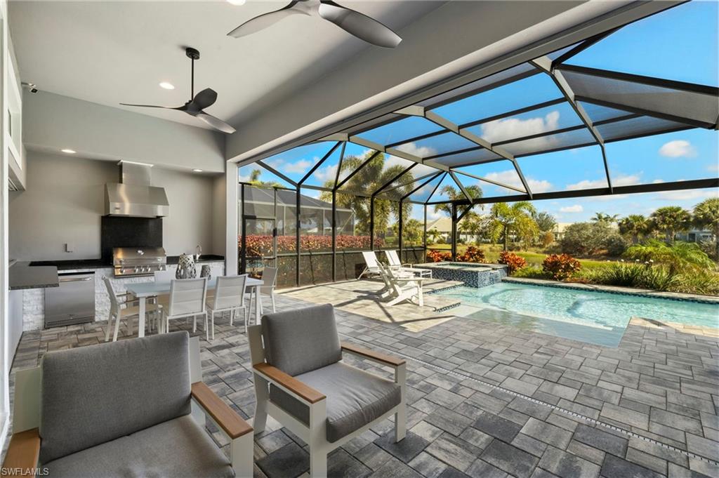 6420 Pembroke Way Naples, FL 34113 - Photo 1 of 39 View of swimming pool with a grill, an in ground hot tub, a patio, and an outdoor kitchen, Electric Storm Screens