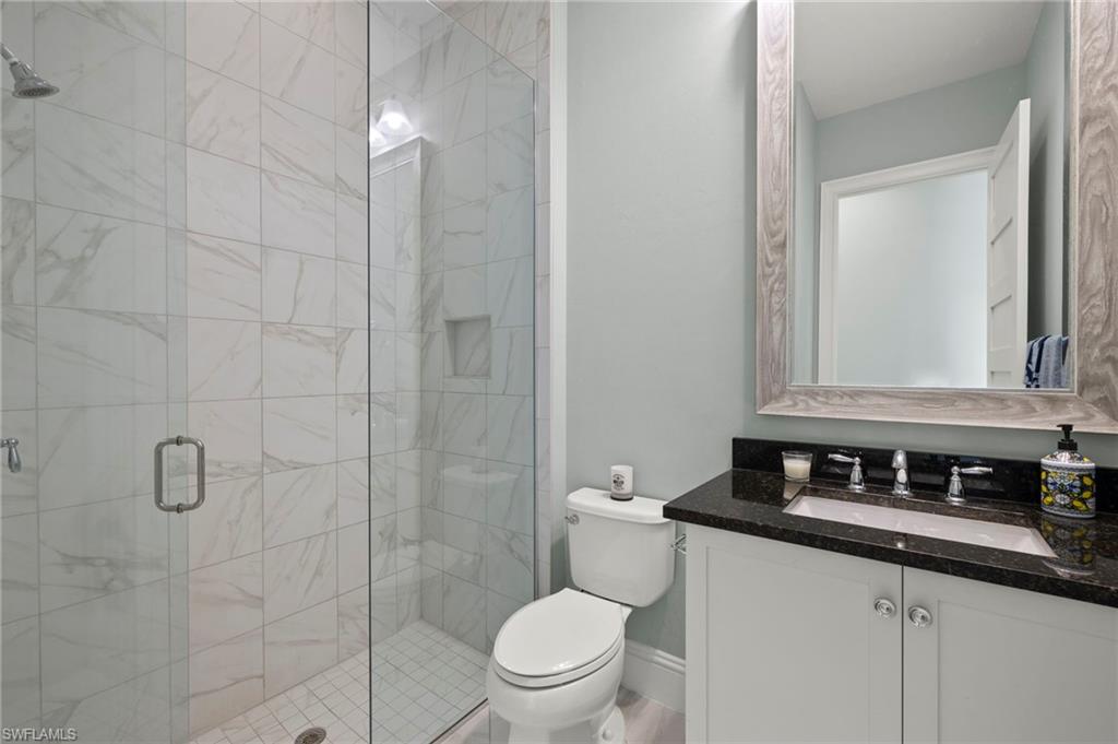 6420 Pembroke Way Naples, FL 34113 - Photo 19 of 39 Bathroom with vanity, toilet, and a shower with shower door
