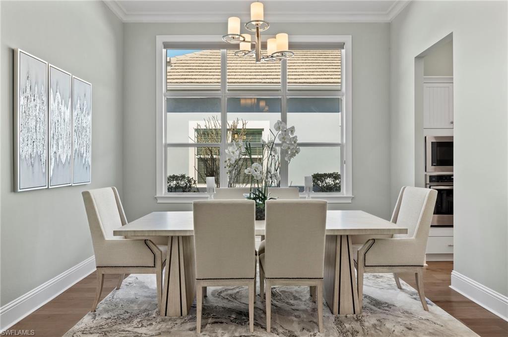 6420 Pembroke Way Naples, FL 34113 - Photo 20 of 39 Dining room featuring ornamental molding, wood-flooring, and a Wall of Windows
