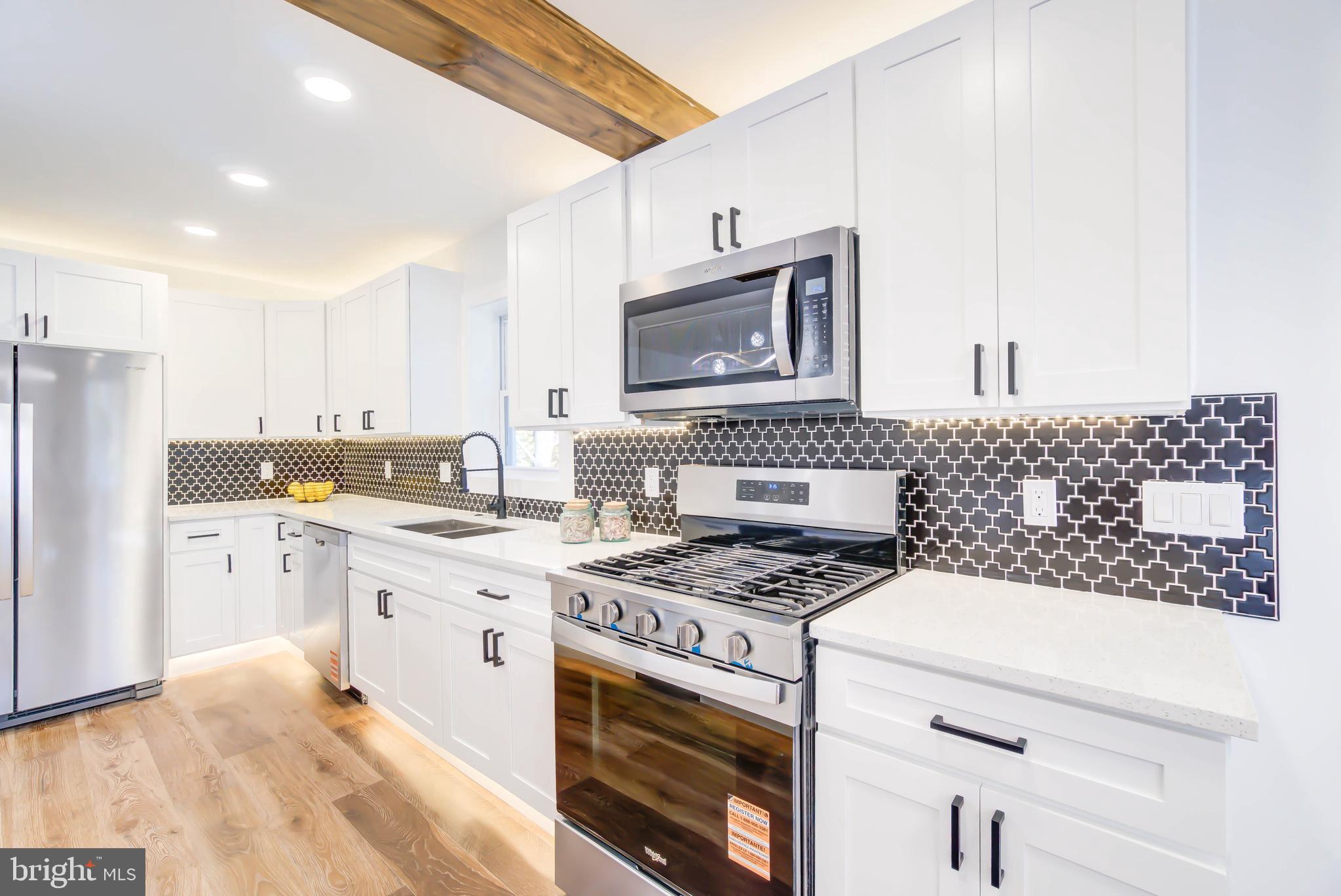 1206 La Grande Road Silver Spring, MD 20903 - Photo 9 of 45 a kitchen with a stove a sink and a refrigerator