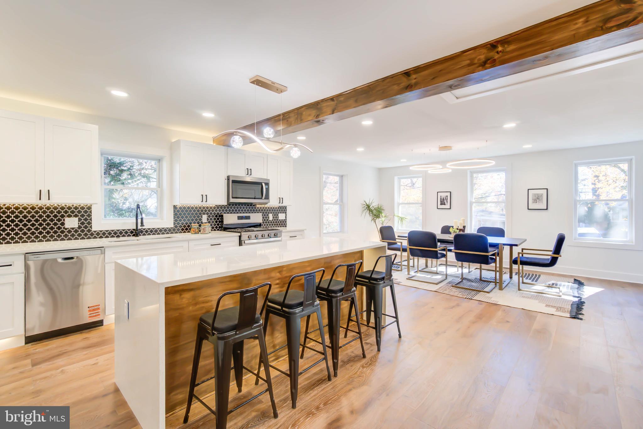 1206 La Grande Road Silver Spring, MD 20903 - Photo 10 of 45 a large white kitchen with lots of counter space a sink and chairs