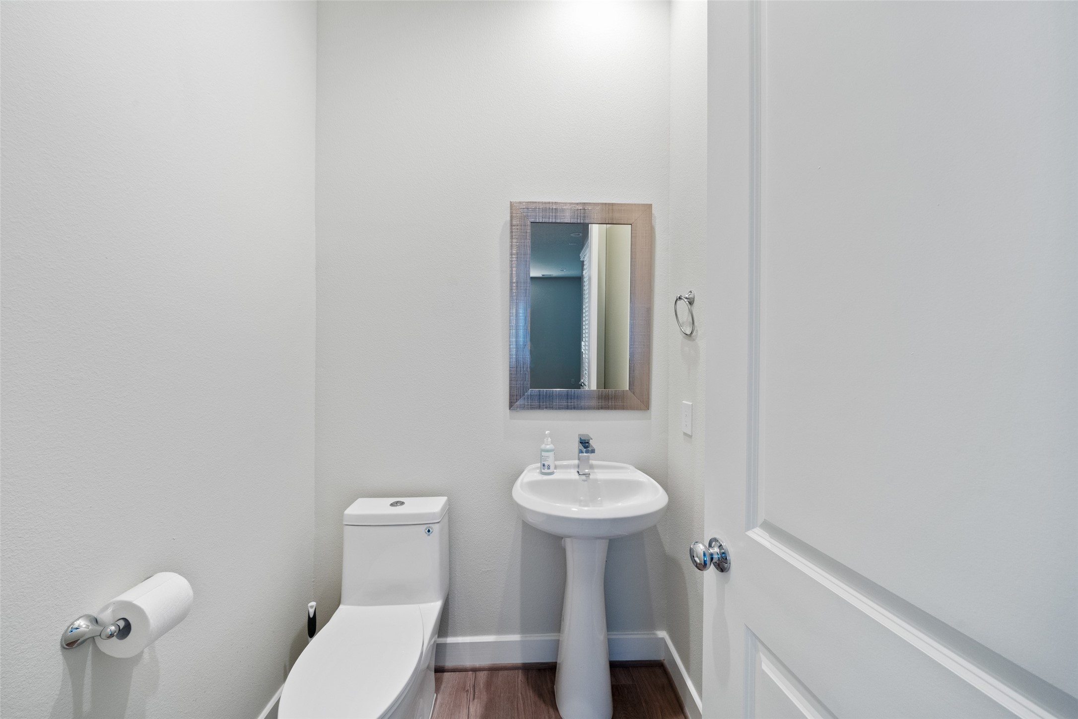 5910 Haring Lane Houston, TX 77091 - Photo 9 of 20 Modern half-bath featuring a pedestal sink, a wall-mounted mirror.