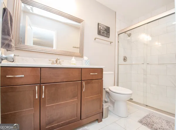 a bathroom with a toilet a sink and mirror