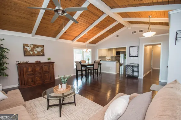 a living room with furniture and a wooden floor