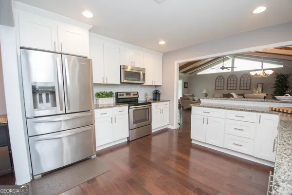 a kitchen with white cabinets and stainless steel appliances