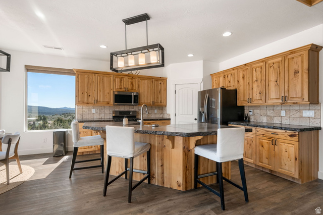 62 North Lucky 7 Road Veyo, UT 84782 - Photo 8 of 43 Kitchen featuring an island with sink, a breakfast bar, and dark wood-style flooring