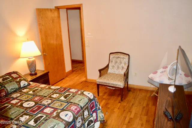 a bedroom with a bed and a lamp with potted plant