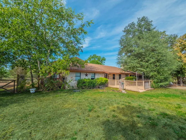 a view of a house with a yard and sitting area