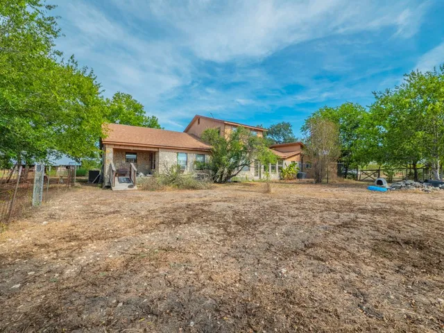 a view of house with backyard and trees