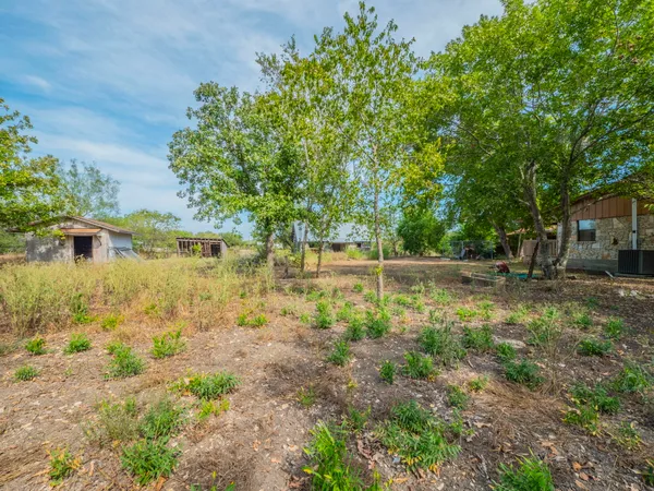 a backyard of a house with lots of green space and fountain