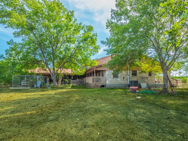 a view of a house with a big yard and large trees