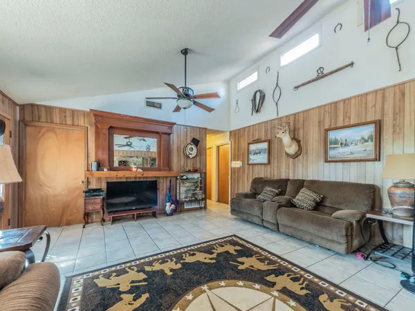 a living room with furniture and a flat screen tv with kitchen view