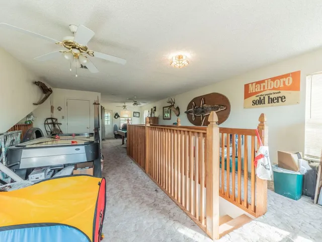 a view of a bedroom with furniture staircase and ceiling fan