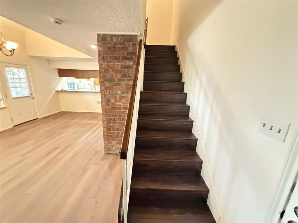 18240 Midway Road, Unit 206 Dallas, TX 75287 - Photo 9 of 16 Dark wood-finish staircase with white risers and a wood handrail