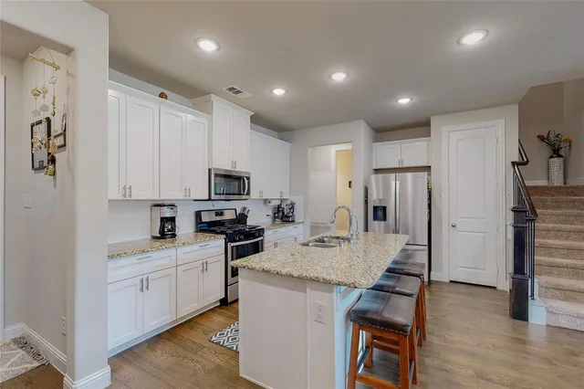 a kitchen with refrigerator cabinets and wooden floor