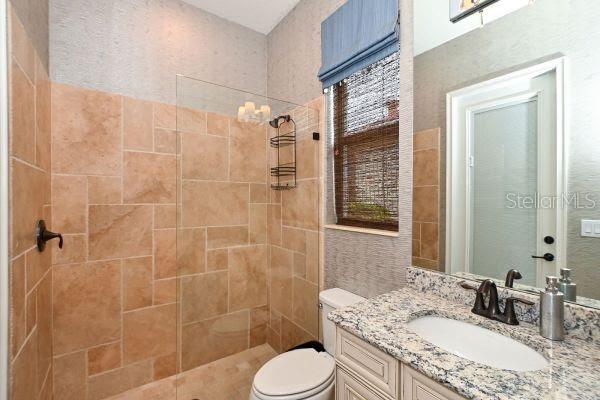 5507 Arnie Loop Lakewood Ranch, FL 34211 - Photo 24 of 68 a bathroom with a granite countertop toilet sink and shower