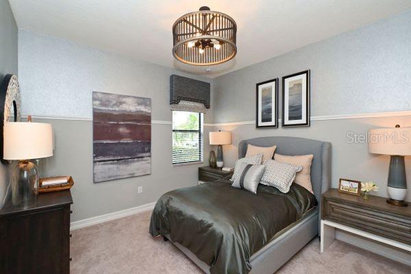 5507 Arnie Loop Lakewood Ranch, FL 34211 - Photo 25 of 68 a bedroom with a bed and a lamp