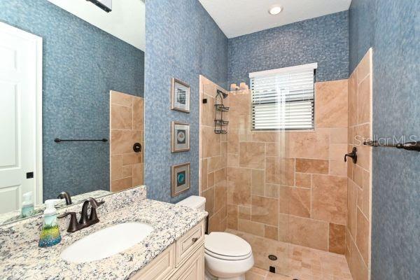5507 Arnie Loop Lakewood Ranch, FL 34211 - Photo 27 of 68 a bathroom with a granite countertop sink toilet a shower and a mirror