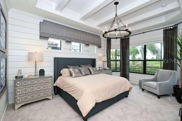 5507 Arnie Loop Lakewood Ranch, FL 34211 - Photo 28 of 68 a spacious bedroom with a bed a couch and large window