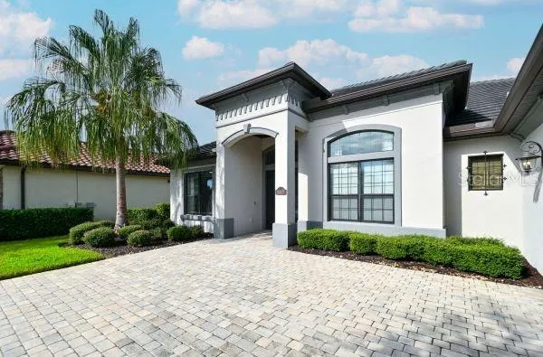 a front view of a house with a yard and potted plants
