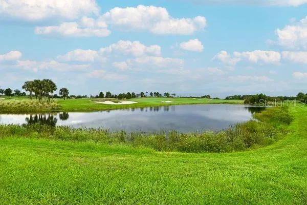 an aerial view of a house with a garden and lake view