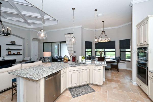 5507 Arnie Loop Lakewood Ranch, FL 34211 - Photo 8 of 68 a kitchen with a stove a kitchen island a sink and a refrigerator