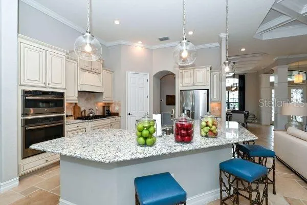 a view of a dining room with furniture a chandelier and large window
