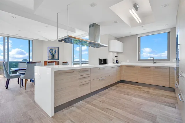 a kitchen with stainless steel appliances kitchen island granite countertop a stove and white cabinets