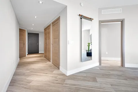 a living room with furniture a flat screen tv and a floor to ceiling window