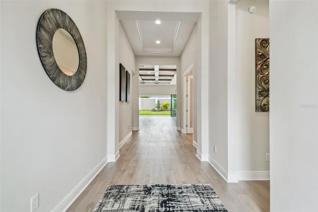 a view of a hallway with wooden floor and a refrigerator