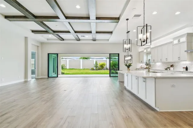 a large white kitchen with kitchen island white cabinets and stainless steel appliances